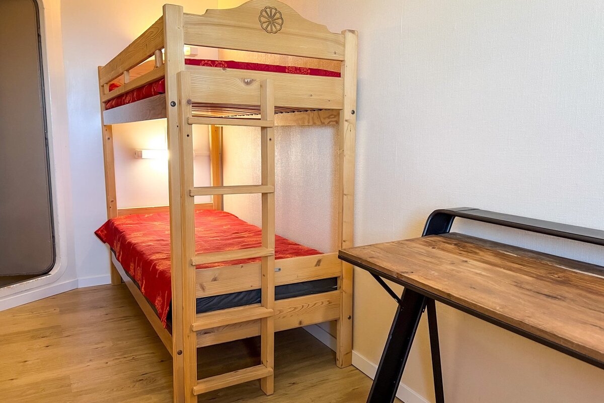 A bunk bed with a red blanket on it