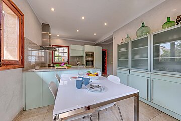 A kitchen with blue cabinets and a white table