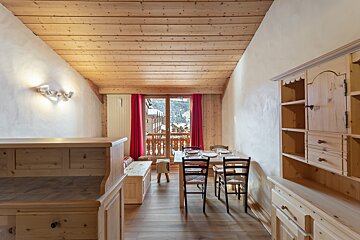 A wooden dining room with a table and chairs