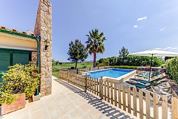 A wooden fence surrounds a large swimming pool