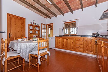 A kitchen with wooden cabinets and a table and chairs