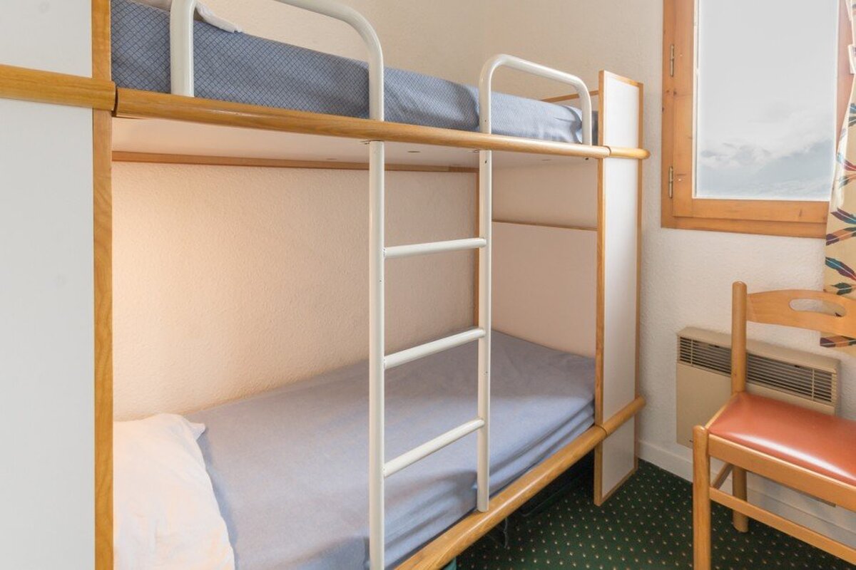 A bunk bed with a ladder and a chair