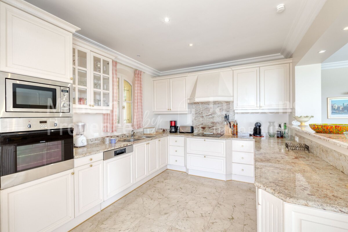 A kitchen with white cabinets and granite counter tops