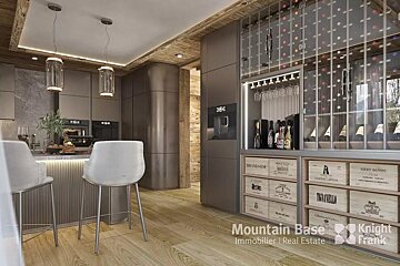 A chic, modern kitchen with dark cabinetry, a breakfast bar, wood accents, and a sophisticated integrated wine storage unit displaying bottles and crates.
