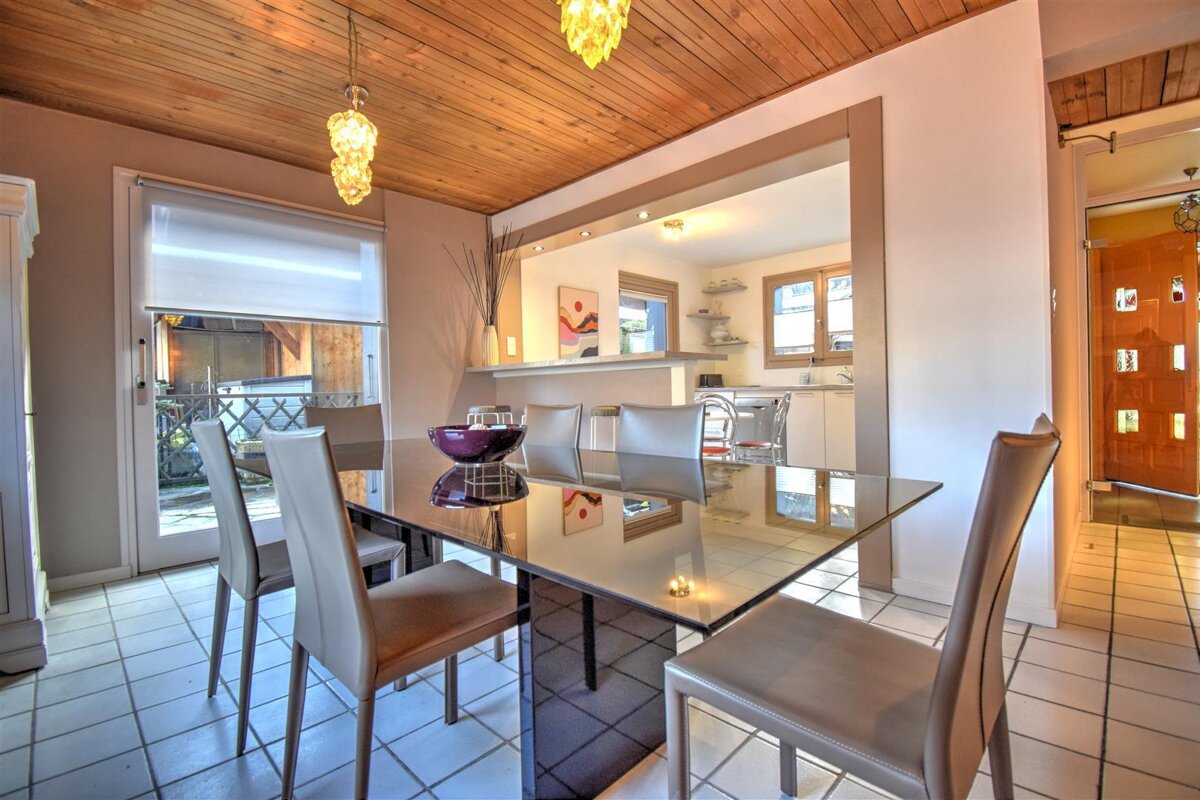 A dining room with a glass table and chairs