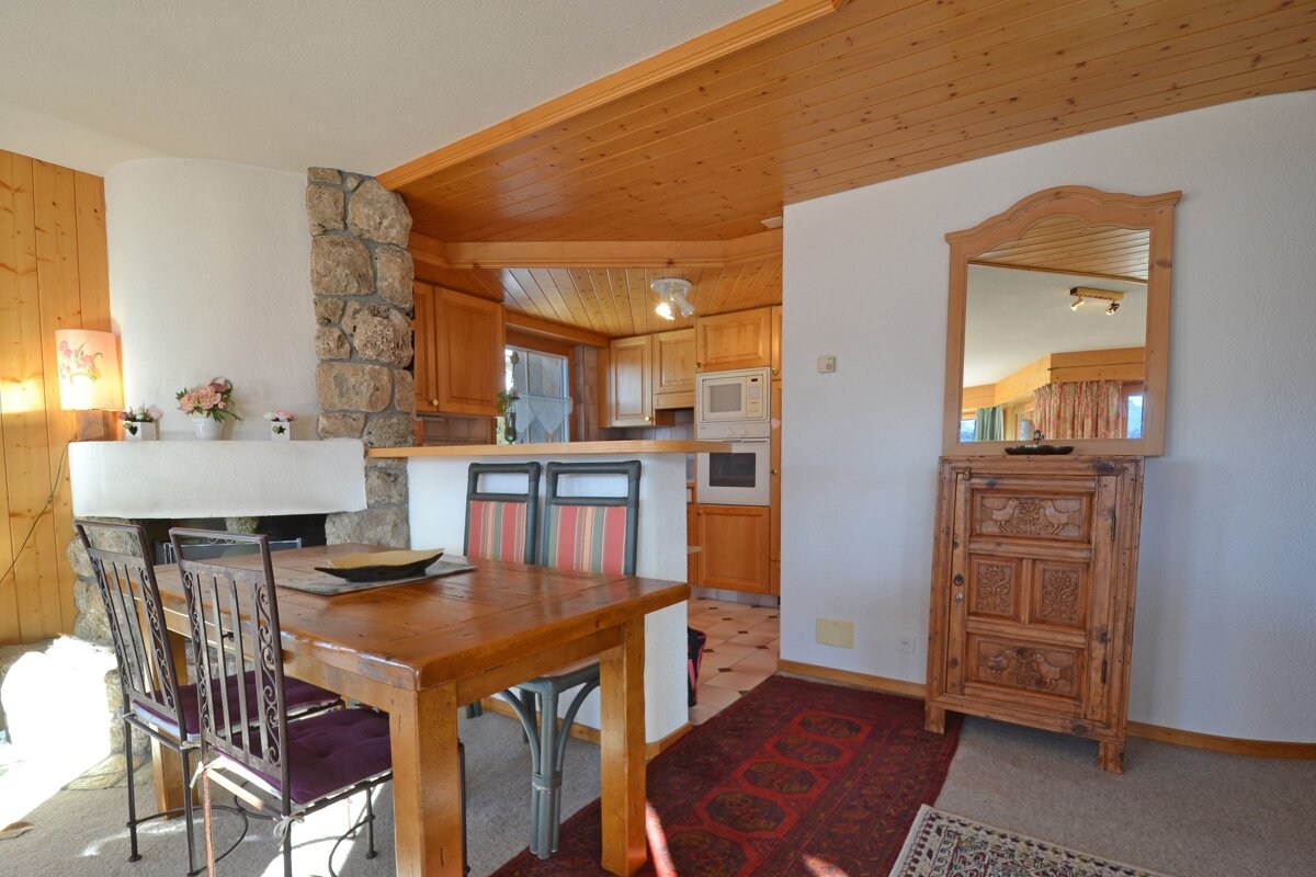 A dining room with a table and chairs and a fireplace
