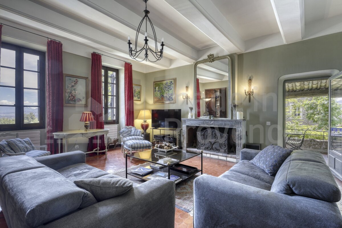 A living room with a couch and a fireplace with the word immobilier on the wall