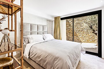 A bedroom with a large bed and a sliding glass door