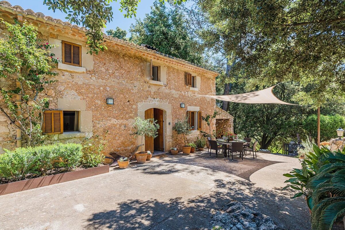 A stone house with a table and chairs in front of it