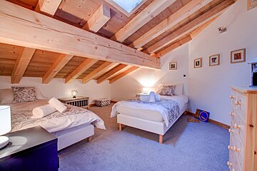 A bedroom with two twin beds and a dresser