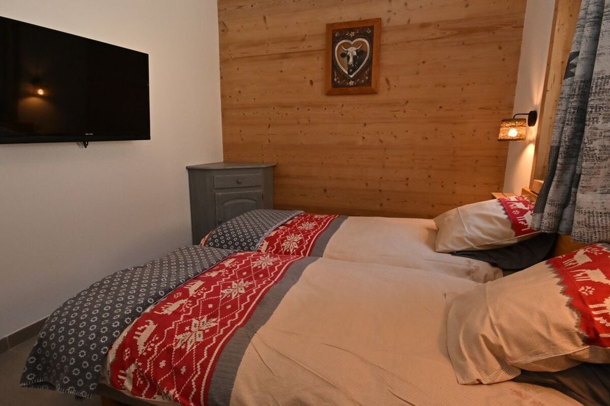 A bedroom with two beds and a flat screen tv
