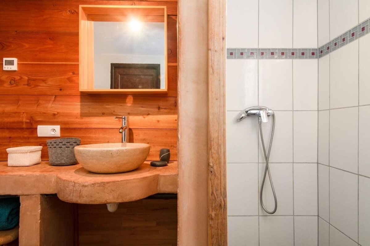 A bathroom with a sink a mirror and a shower