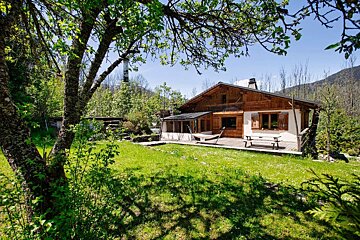 A wooden house with a picnic table in front of it