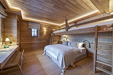 A bedroom with bunk beds and a desk