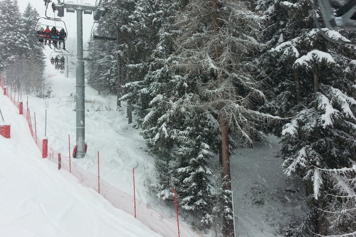 snow falling over a chair lift in les arcs