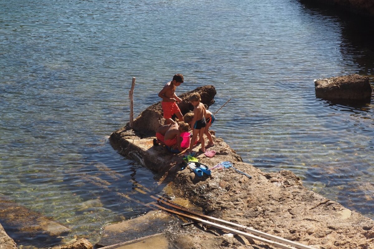 young boys fishing off the coast at cala corral