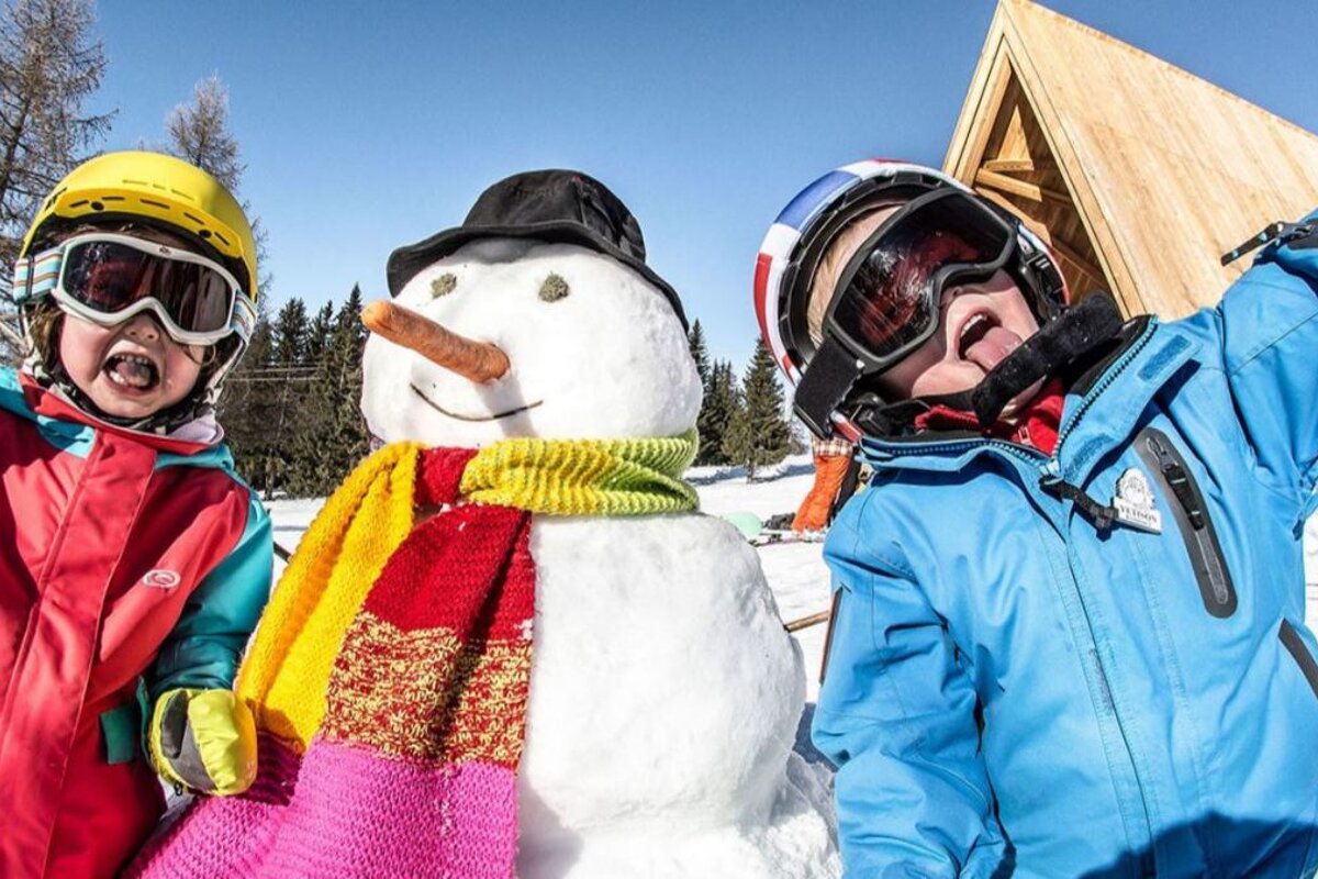 children with a snowman in les arcs