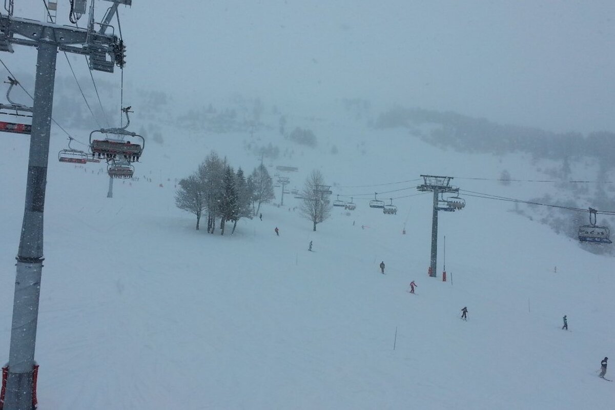 a ski lift with snow falling in les arcs