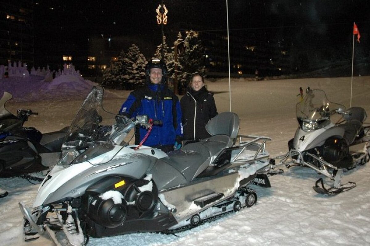 a couple with a snowmobile at night