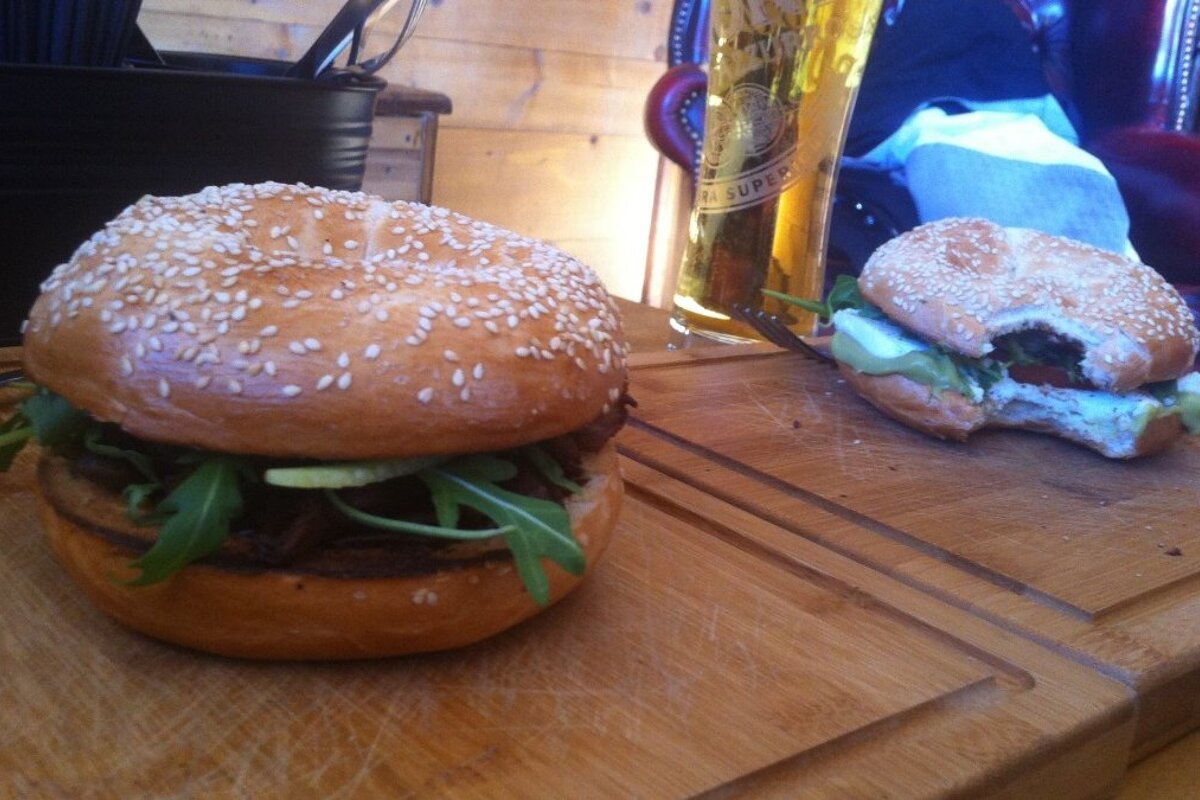 two burgers on wooden boards