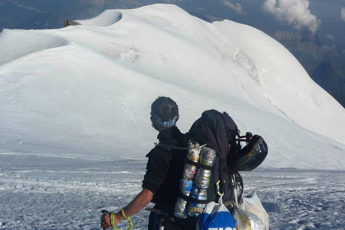 mountaineer on mont blanc with bags of rubbish
