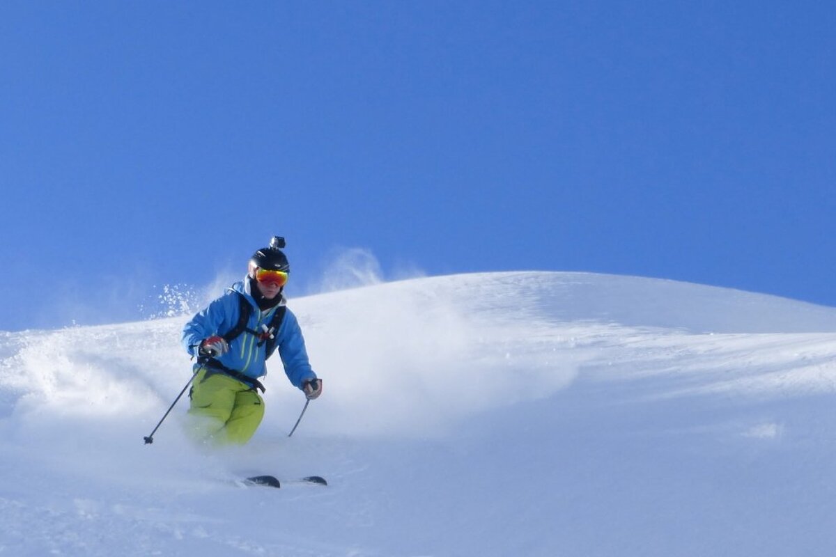 a skier with blue skies behind