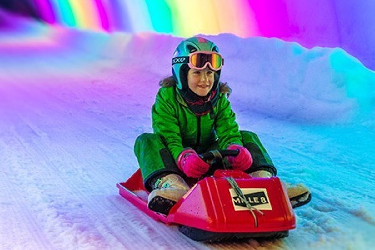 a child on a sledge in a coloured tunnel