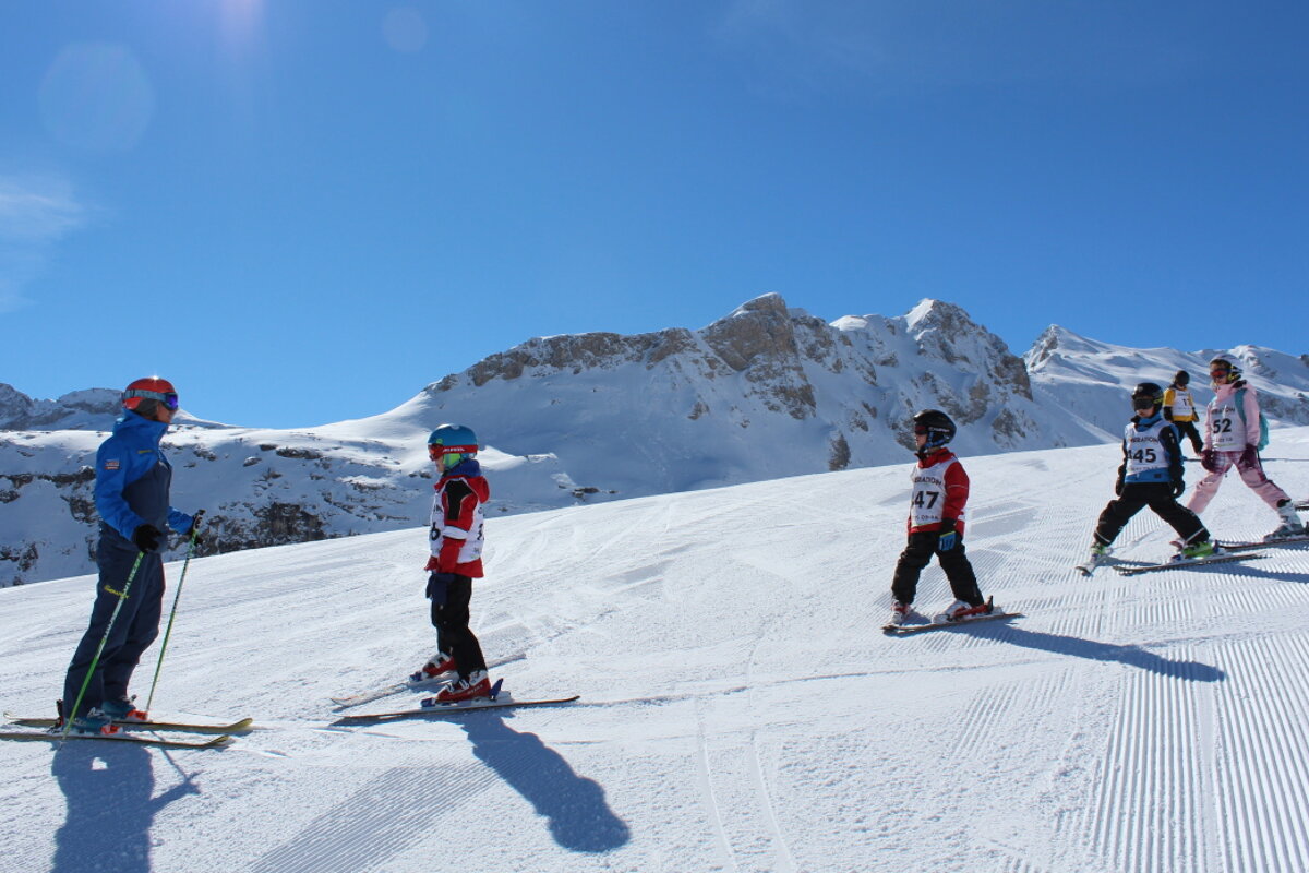 children following a ski instructor