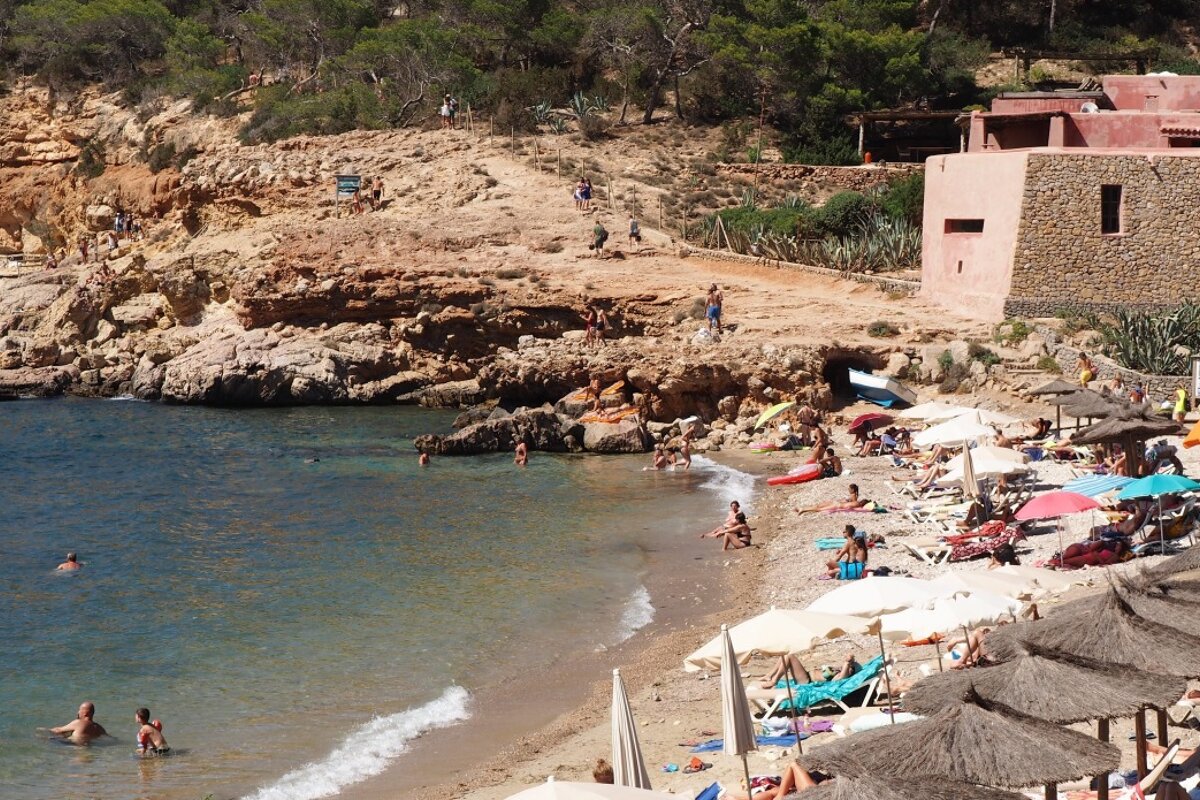 the beach at cala salada with umbrellas and sun loungers west ibiza