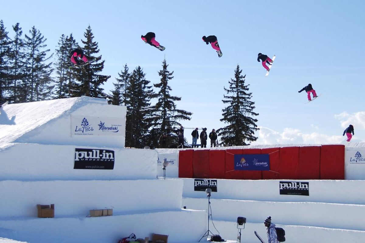 a sequence photo of a snowboarder on a big kicker