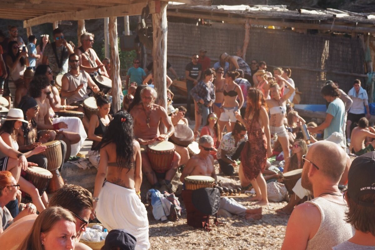 Crowds dancing and drumming on benirras beach ibiza