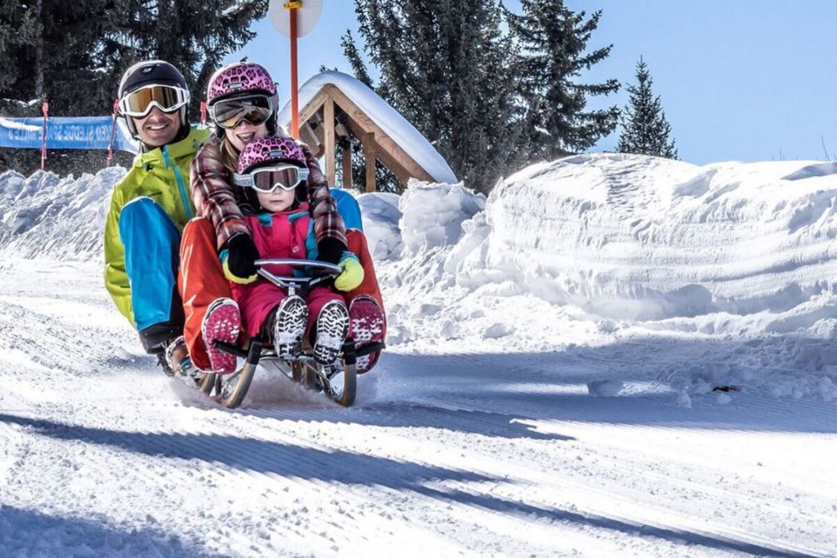 a family on a sledge at mille 8 in les arcs