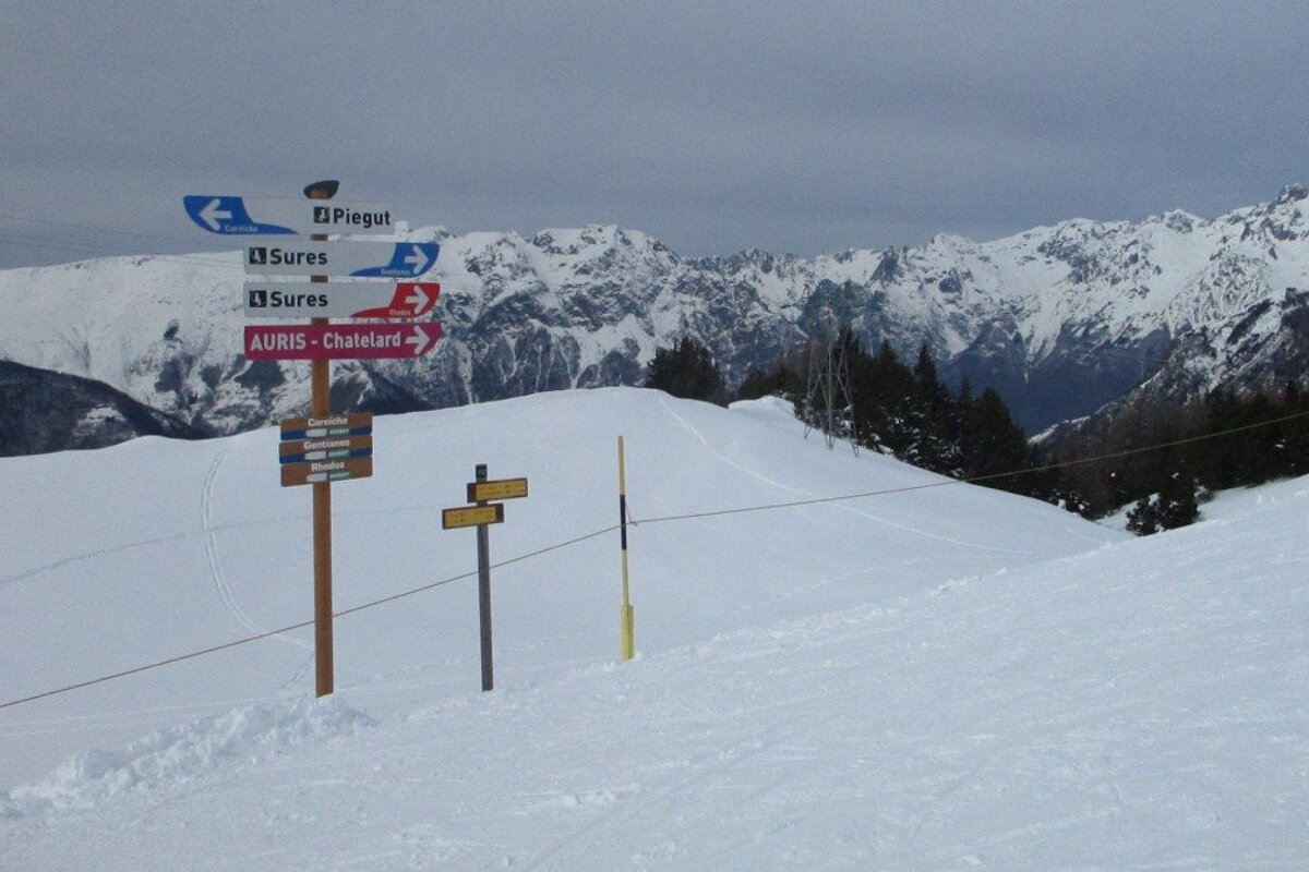 a sign pointing to auris in alpe dhuez ski area