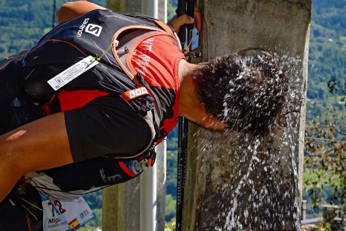 a man with his head under a tap