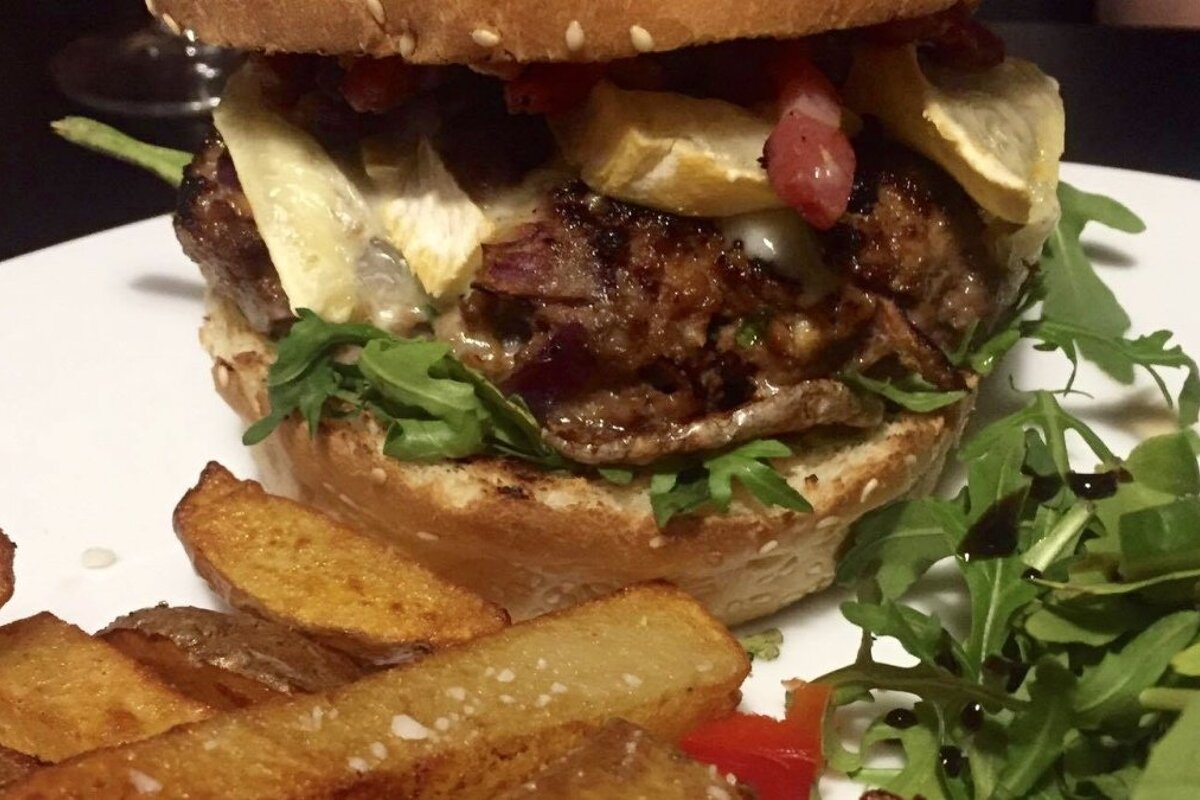 a well stuffed burger with chips