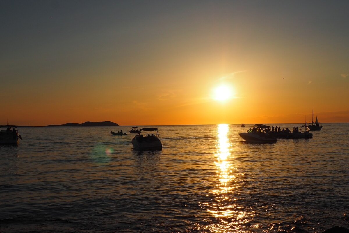 boats floating in the water off san antonio as the sunsets in ibiza