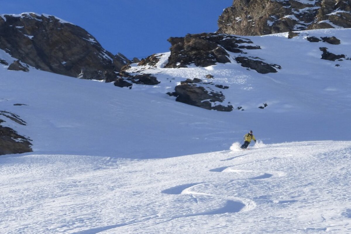 a man skiing in a yellow jacket