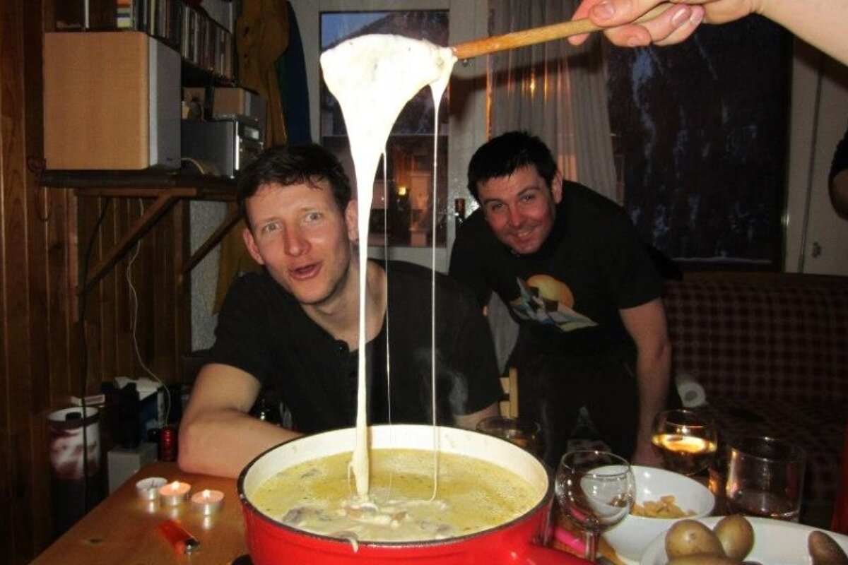 some men in an apartment making fondue