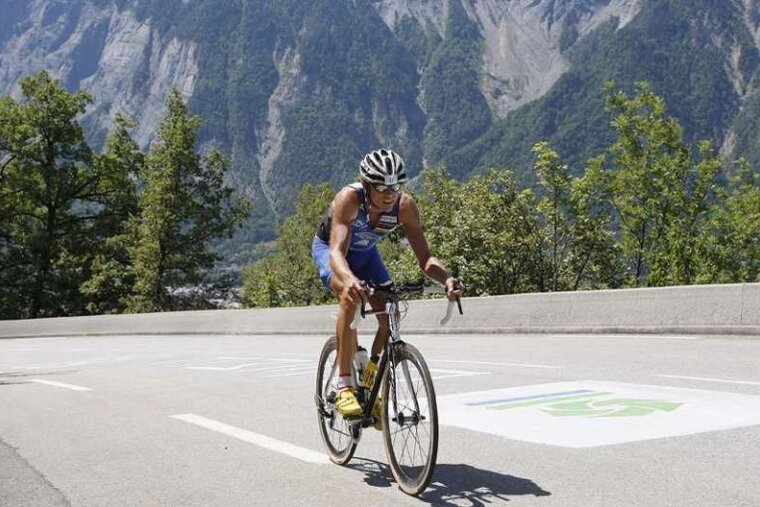 Triathlete cycling up the 21 bends of Alpe d'Huez