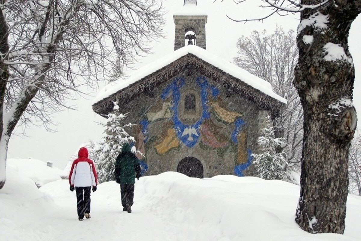 Winter Walking two walkers in the snow going towards a church